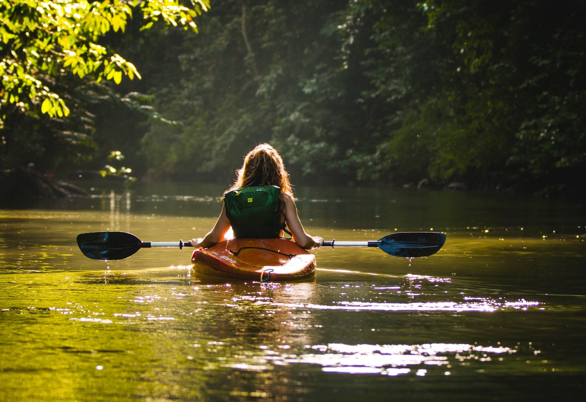 woman in river kayaking 